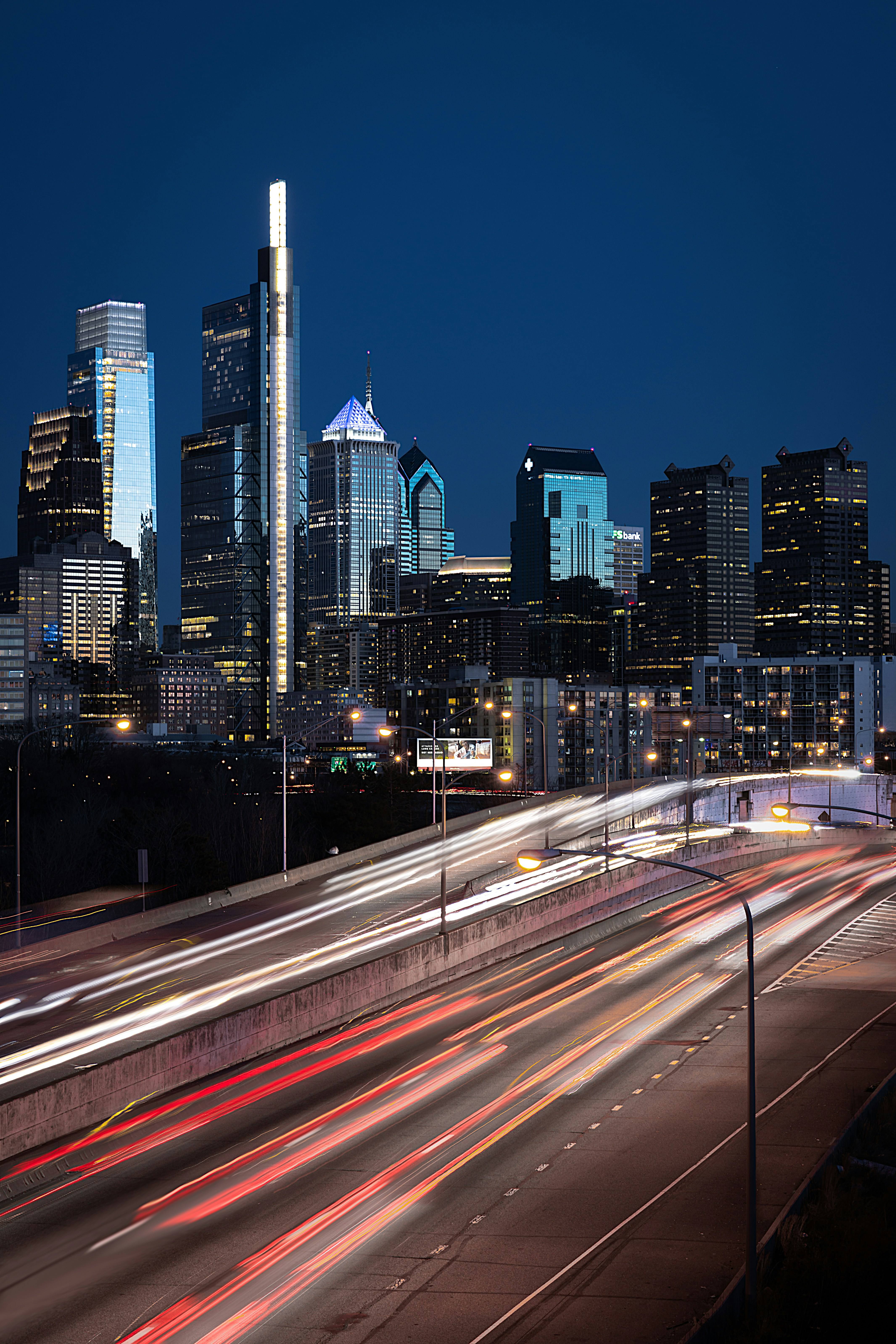 The Philadelphia skyline at night, with light trails from traffic on the highway below